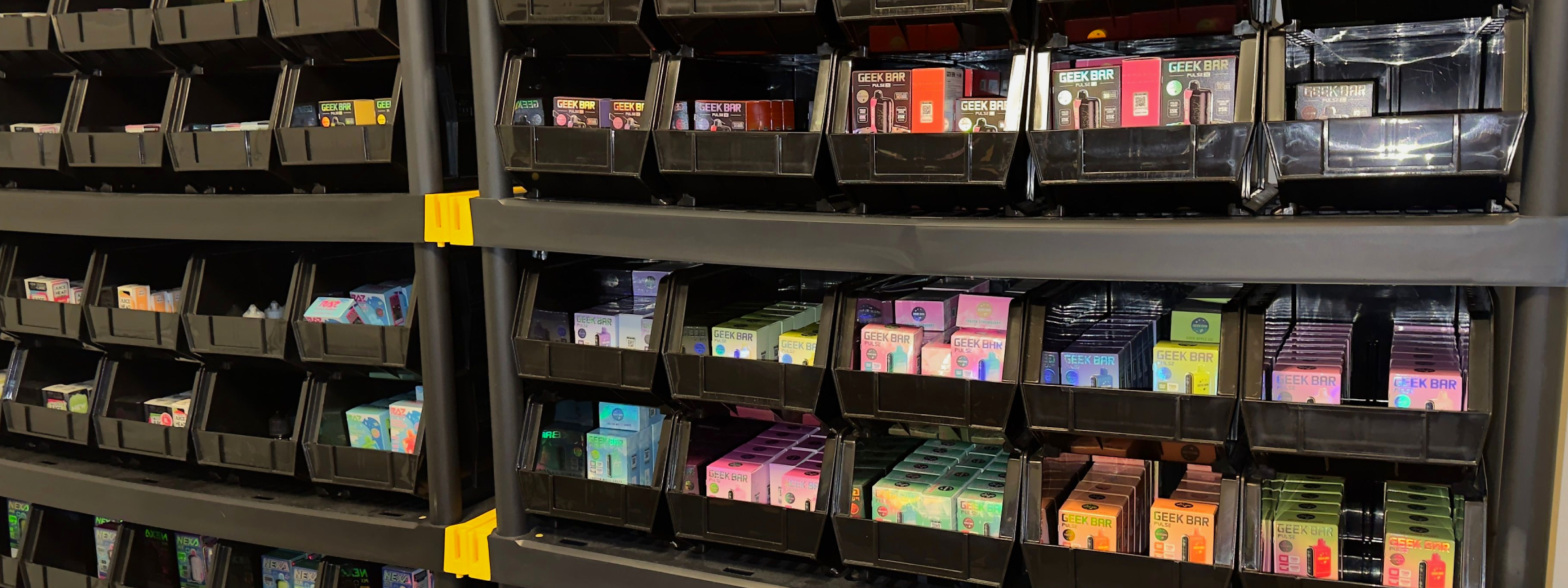 Puff Playground warehouse shelves fully stocked with Geek Bar Pulse X and other disposable vapes.
